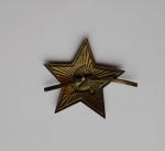 Red star on his cap/hat.